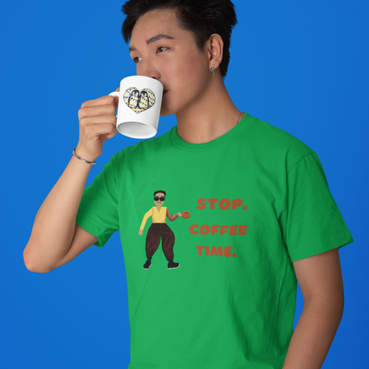 Person wearing a green t-shirt with a pixel art graphic and "Stop. Coffee time" on it, drinking from a mug against a blue background