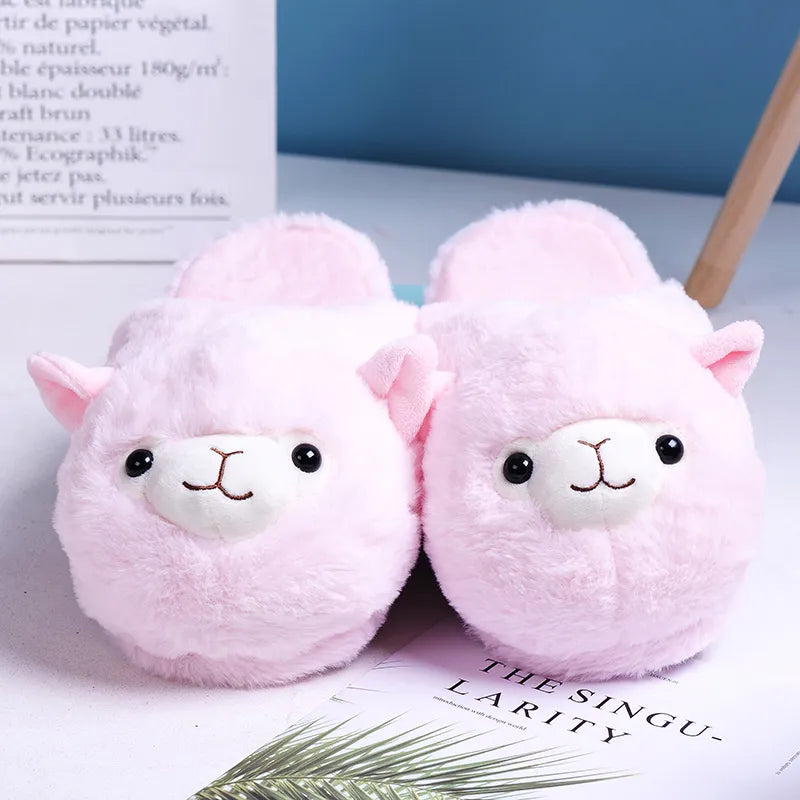 Light pink plush slip-on slippers resembling smiling alpacas, featuring their charming faces on the front with delightful beaded eyes.